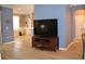 Open-concept living area features modern flooring, neutral walls, and an entertainment center with a large screen TV at 8678 Sw 83Rd Cir, Ocala, FL 34481