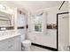 Charming bathroom featuring a modern vanity, black-and-white floors and a window with lace curtain at 1226 Se 9Th Ave, Ocala, FL 34471