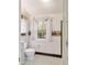 Well-lit bathroom showcases black-and-white tiled floors and a window with decorative lace curtain at 1226 Se 9Th Ave, Ocala, FL 34471