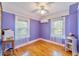 Cozy bedroom features hardwood floors, two windows with white curtains, and a ceiling fan with light fixture at 1226 Se 9Th Ave, Ocala, FL 34471