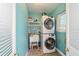 Modern laundry room features stacked washer and dryer, utility sink, and bright blue walls at 1226 Se 9Th Ave, Ocala, FL 34471