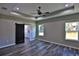 Spacious bedroom with wood-look flooring, ceiling fan, and barn door at Tbd W C 466 # Lot 1, Oxford, FL 34484