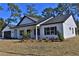 White farmhouse exterior with black garage door at Tbd W C 466 # Lot 1, Oxford, FL 34484