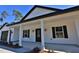 Inviting front porch with black columns and stylish lanterns at Tbd W C 466 # Lot 1, Oxford, FL 34484