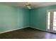 Light teal bedroom with wood-look flooring and sliding glass door at 7865 Sw 115Th Loop, Ocala, FL 34476