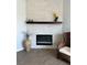 Modern fireplace with white stone surround and dark wood mantel at 7865 Sw 115Th Loop, Ocala, FL 34476