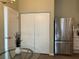 Stainless steel refrigerator and white cabinetry in kitchen at 7865 Sw 115Th Loop, Ocala, FL 34476