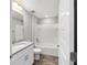 Bathroom with a single sink vanity, granite countertop, and tub with white shower at 13359 Sw 80Th St, Dunnellon, FL 34432