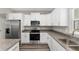 Modern kitchen featuring stainless steel appliances, granite countertops, and white cabinetry at 13359 Sw 80Th St, Dunnellon, FL 34432