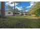 Backyard view featuring the home exterior, lush grass, and mature trees at 8655 Sw 98Th Street Rd # G, Ocala, FL 34481