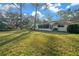 Large backyard featuring lush green grass, trees, and the exterior of the home at 8655 Sw 98Th Street Rd # G, Ocala, FL 34481