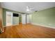 Primary bedroom with wood floors, green walls, white ceiling fan and view of ensuite at 8655 Sw 98Th Street Rd # G, Ocala, FL 34481