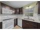Kitchen features updated white appliances, dark cabinets and a stainless steel sink beneath a window at 8655 Sw 98Th Street Rd # G, Ocala, FL 34481