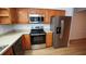 Modern kitchen with stainless steel appliances and wood cabinets at 11001 Se Sunset Harbor Rd # A08, Summerfield, FL 34491