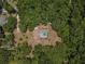 Bird's eye view of a single-story home and screened-in pool, encircled by a dense forest at 15235 Se 63Rd Ave, Summerfield, FL 34491