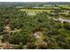 Overhead view of a secluded property, outlined in red, featuring a home and pool surrounded by dense trees at 15235 Se 63Rd Ave, Summerfield, FL 34491