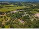 A high-angle aerial view of private home and pool, surrounded by dense trees, on a sprawling green property at 15235 Se 63Rd Ave, Summerfield, FL 34491