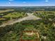 High angle view of a home with a pool, outlined in red, nestled amongst the trees and a lake at 15235 Se 63Rd Ave, Summerfield, FL 34491