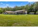 Exterior view of a house with a pool, shed, and spacious green yard at 15235 Se 63Rd Ave, Summerfield, FL 34491