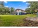 Backyard view of a two-story home with a screened in pool and shed at 15235 Se 63Rd Ave, Summerfield, FL 34491