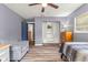 Bedroom featuring wood-look floors, neutral blue walls, a ceiling fan, and an adjacent closet at 15235 Se 63Rd Ave, Summerfield, FL 34491