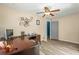 Bedroom with wood-look floors, tan walls, and ceiling fan at 15235 Se 63Rd Ave, Summerfield, FL 34491