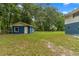 Exterior view of a home with a separate structure in a lush, grassy yard at 15235 Se 63Rd Ave, Summerfield, FL 34491