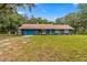 Charming single-story home with a vibrant blue exterior and well-maintained lawn at 15235 Se 63Rd Ave, Summerfield, FL 34491