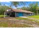 Single-story brick home featuring a drive-through carport, front porch, and a well-manicured lawn at 15235 Se 63Rd Ave, Summerfield, FL 34491