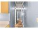 Hallway with wood-look flooring and neutral blue walls leading to other rooms in the house at 15235 Se 63Rd Ave, Summerfield, FL 34491