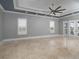 Bright bedroom features a tray ceiling, plantation shutters, and elegant flooring at 3440 Sw 66Th St, Ocala, FL 34476