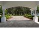 View through a covered arched entryway to a lush green landscape at 3440 Sw 66Th St, Ocala, FL 34476