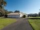 Three-car garage with circular driveway and lush landscaping at 3440 Sw 66Th St, Ocala, FL 34476