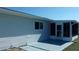 A view of the back of the property with a grey patio and screened in porch and blue skies at 10926 Sw 78Th Ct, Ocala, FL 34476