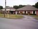 Well-maintained building exterior with a circular driveway and manicured landscaping, creating a welcoming entrance at 10926 Sw 78Th Ct, Ocala, FL 34476