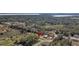 Beautiful aerial view of new construction home nestled among mature trees with view of lake in the distance at 35 Locust Terrace Way, Ocala, FL 34472