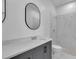 Modern bathroom featuring sleek gray vanity, oval mirror, and tiled walk-in shower at 35 Locust Terrace Way, Ocala, FL 34472