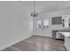 Bright dining room featuring gray floors, a modern chandelier, and a door leading to the outside at 35 Locust Terrace Way, Ocala, FL 34472