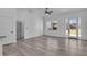 Spacious living room with gray floors, a white ceiling, and a glass door leading to the backyard at 35 Locust Terrace Way, Ocala, FL 34472