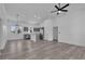 Open-concept living room with gray floors, a ceiling fan, and a view into the kitchen area at 35 Locust Terrace Way, Ocala, FL 34472