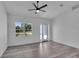 Open-concept living room boasting wood-look floors, a ceiling fan, and a glass-paneled door at 5394 Nw 6Th Pl, Ocala, FL 34482