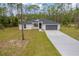 Front exterior of a single-story home featuring a gray roof, white siding, and a well-manicured lawn at 4444 Sw 118 Ter, Ocala, FL 34481