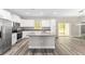 Well-lit kitchen with an island, granite countertops, stainless steel appliances, and wood-look floors at 4444 Sw 118 Ter, Ocala, FL 34481