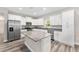 The bright kitchen has an island, stainless steel appliances, granite countertops, and white cabinetry at 4444 Sw 118 Ter, Ocala, FL 34481