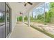 Covered patio featuring white columns, ceiling fans, and a view of the natural surroundings at 4444 Sw 118 Ter, Ocala, FL 34481