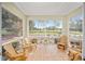 Relaxing screened porch with wooden chairs and view of nature at 8345 Sw 82Nd Loop, Ocala, FL 34481