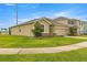 Exterior view of a well-maintained home featuring green grass, stone accents, and a cozy neighborhood setting at 8996 Sw 49Th Cir, Ocala, FL 34476