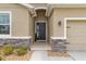 Inviting front entry featuring stone accents, a well-lit porch, and a stylish front door at 8996 Sw 49Th Cir, Ocala, FL 34476