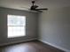 Bright bedroom features a ceiling fan, wood floors, and natural light from the window at 13083 Sw 61St Place Rd, Ocala, FL 34481