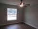 Bright bedroom features a ceiling fan, wood floors, and natural light from the window at 13083 Sw 61St Place Rd, Ocala, FL 34481